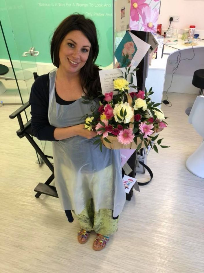 Katy Jobbins receiving flowers from permanent makeup student