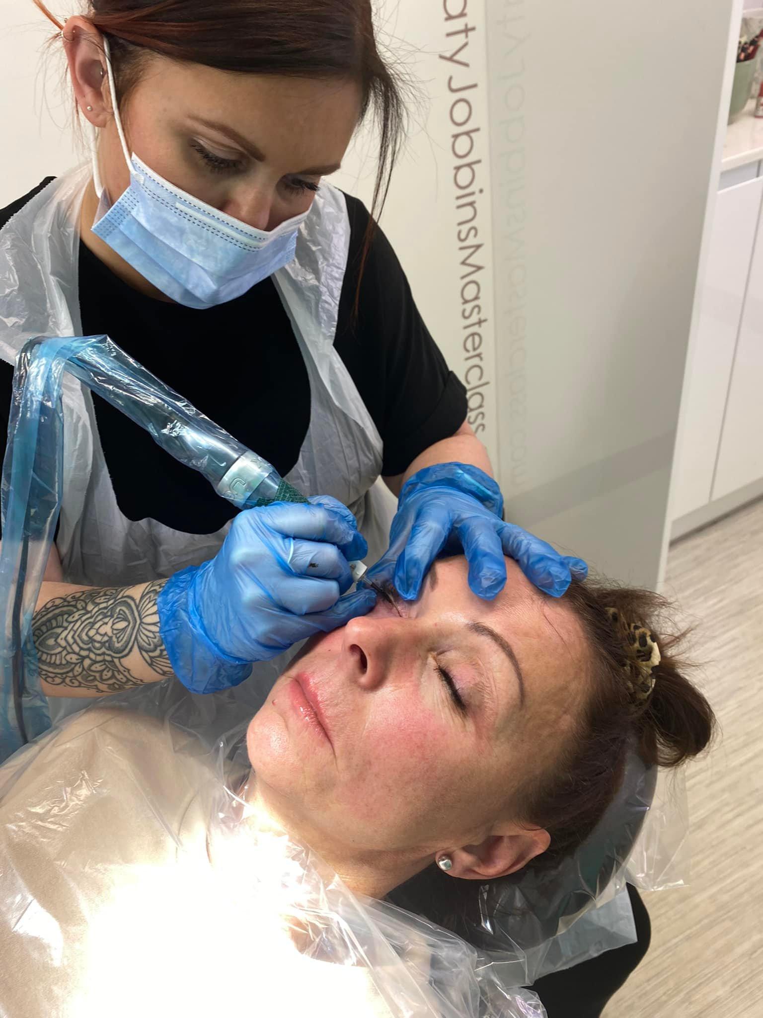 Lori-ann performing permanent eyeliner on a client
