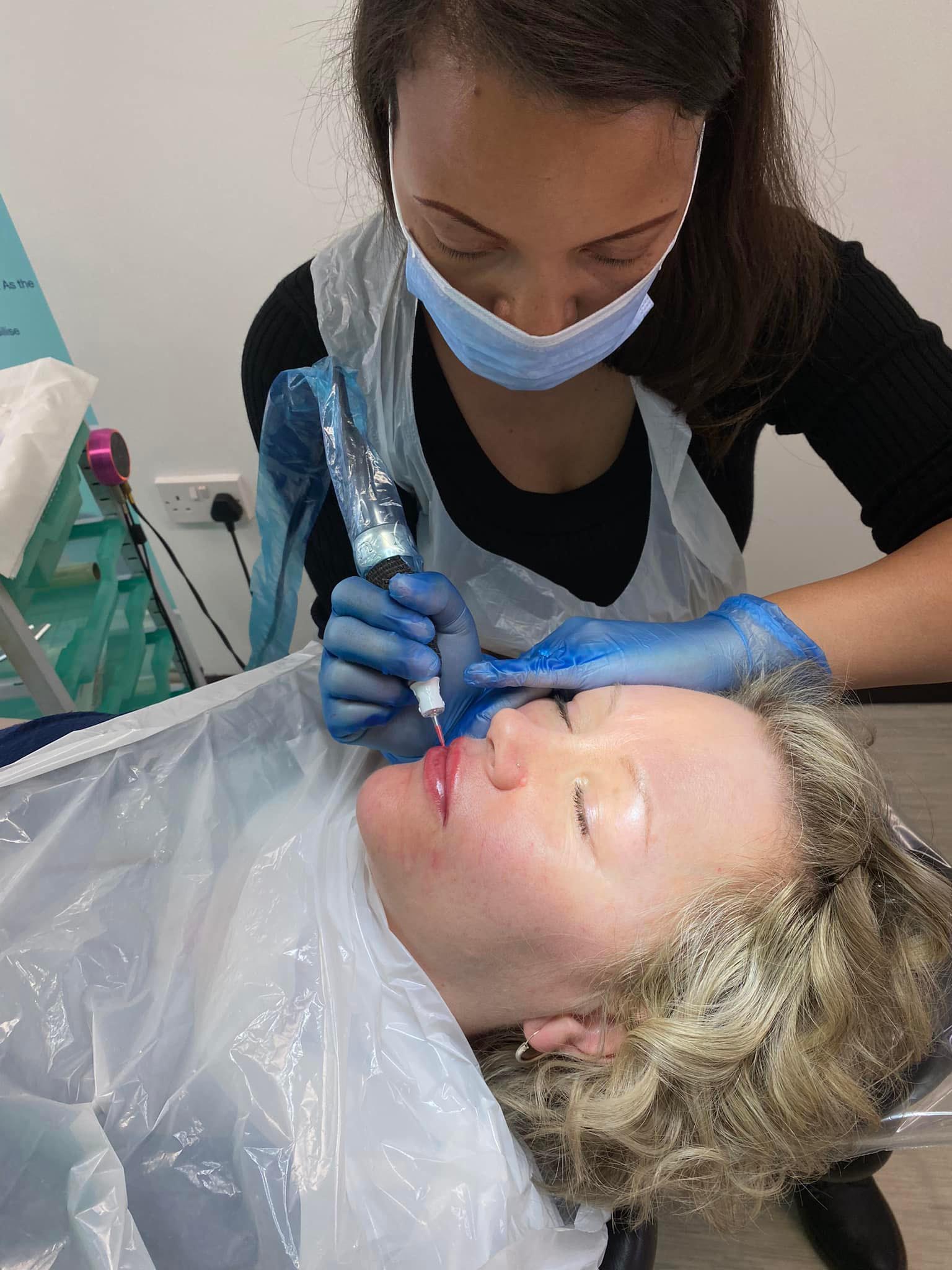 Collette performing permanent lip tattoo to a client