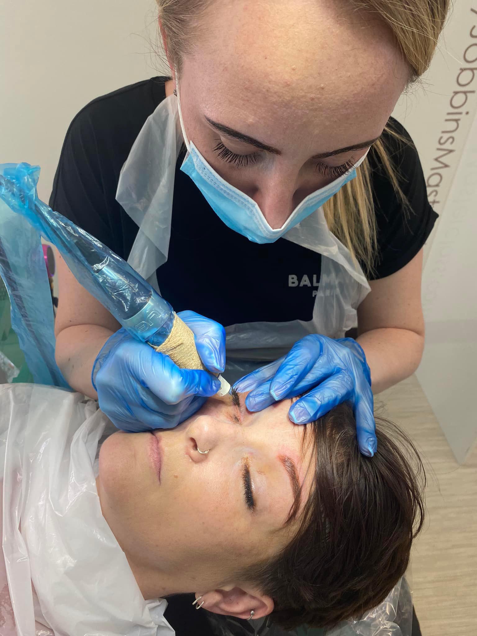 Danielle performing permanent eyeliner treatments on her client during training