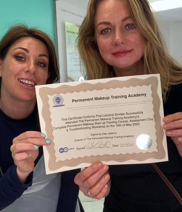 Lorraine holding her Permanent Makeup Training certificate with Katy Jobbins