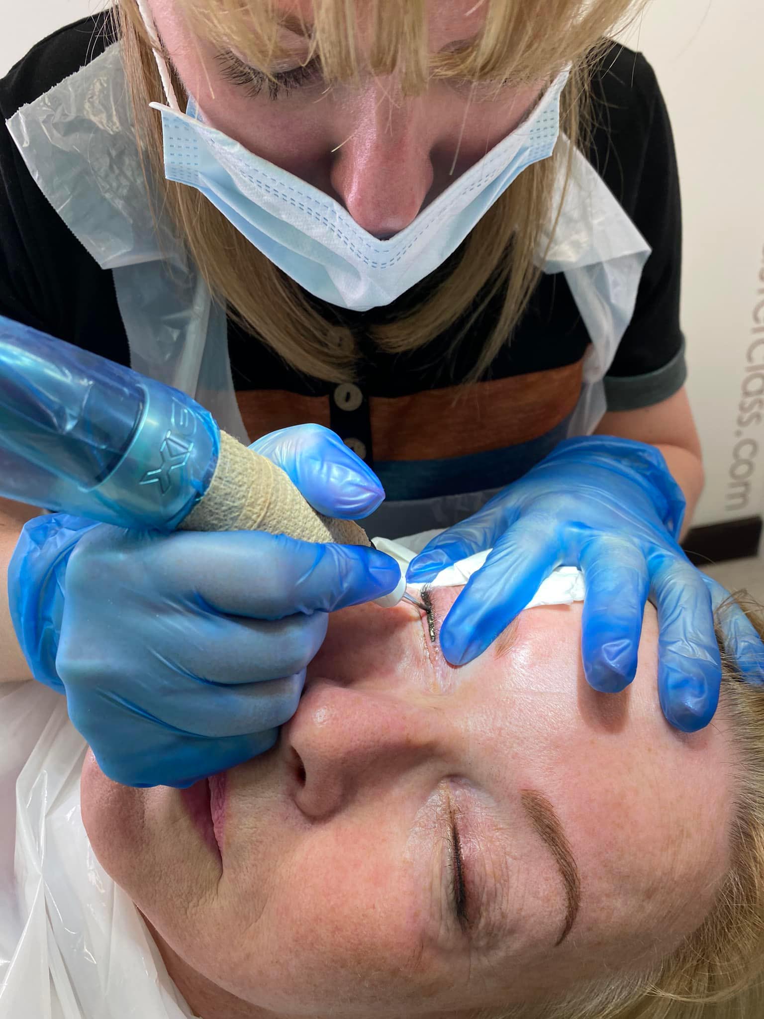 Jenny performing permanent eyeliner on her client