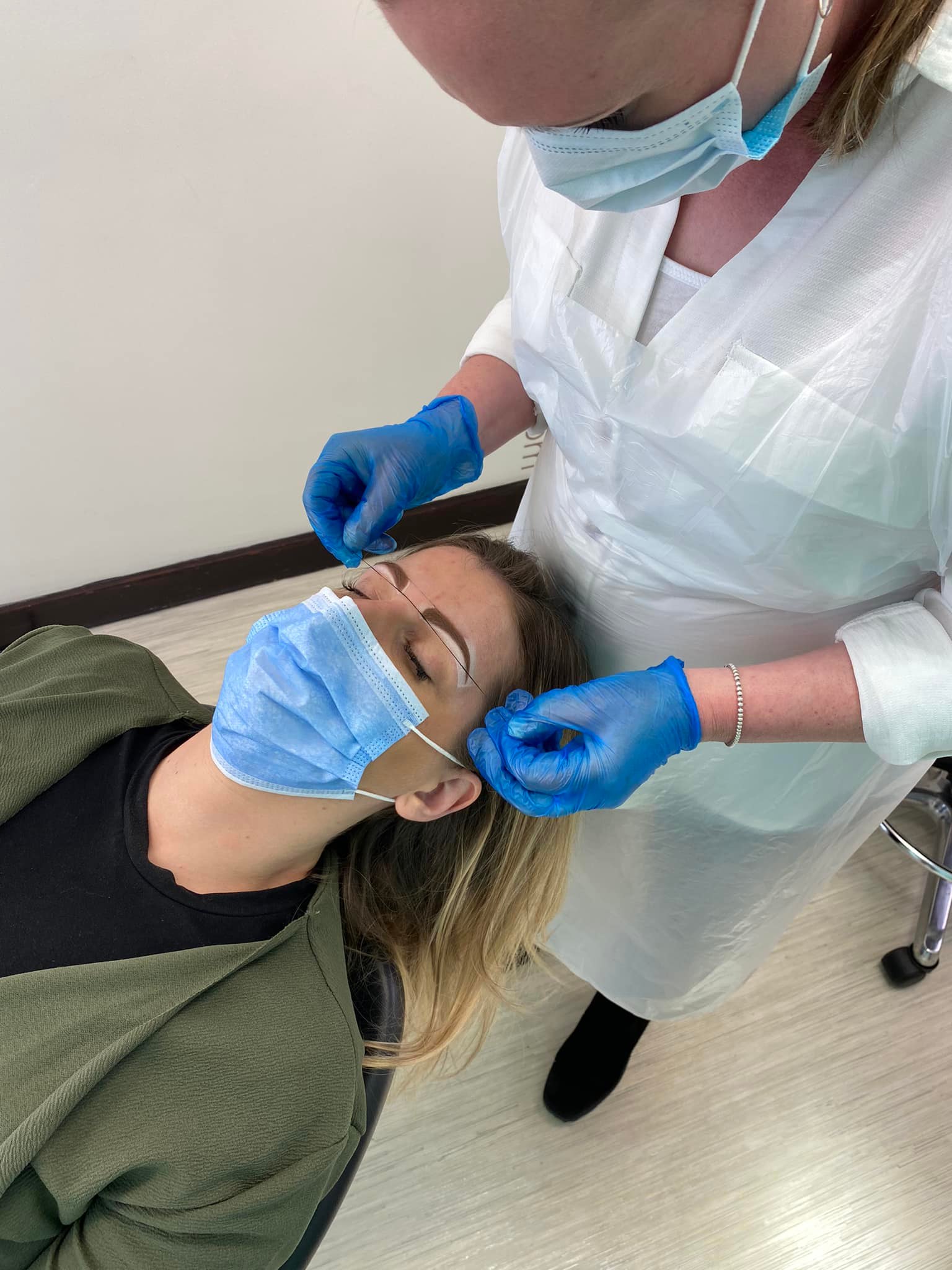 Caroline measuring and perfecting her client's permanent eyebrows