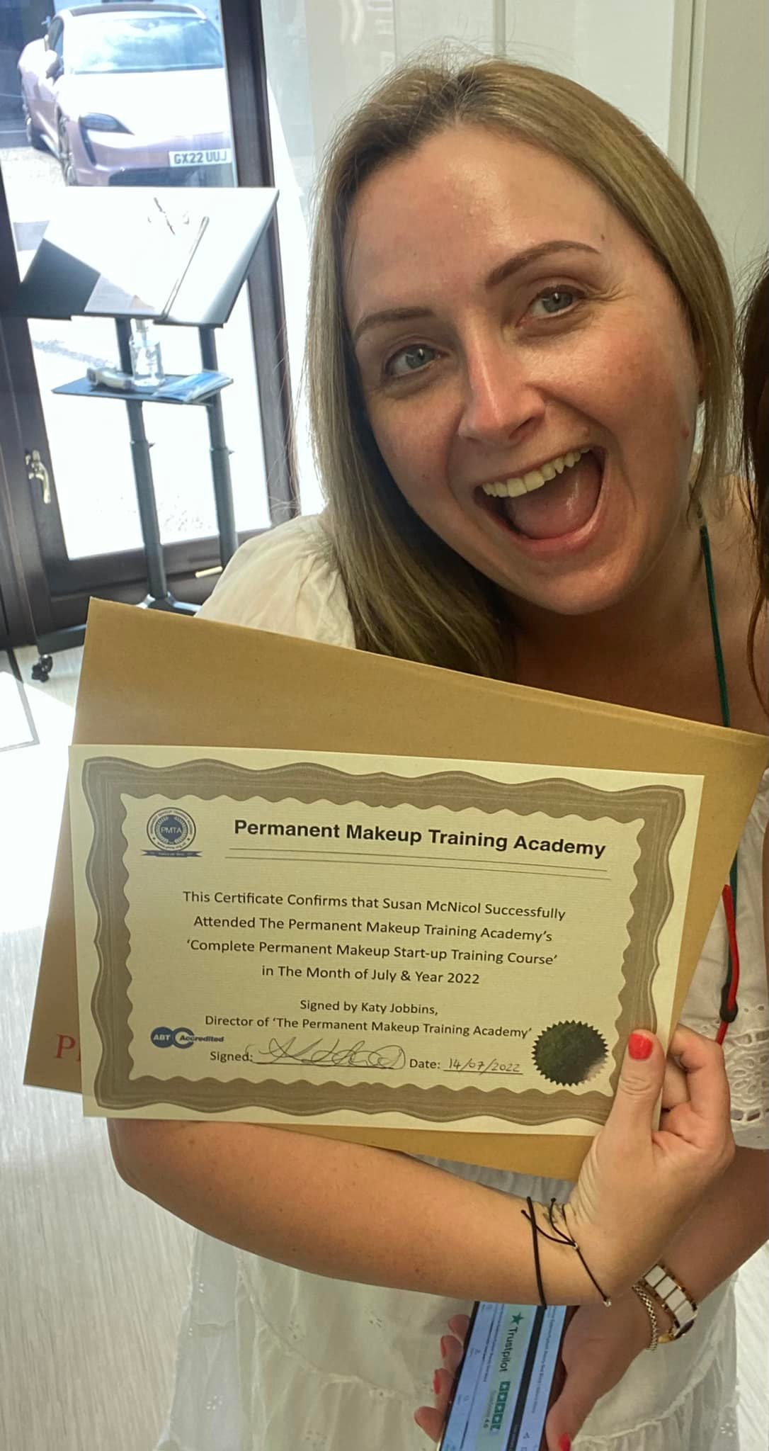 Susan receiving her permanent makeup training certificate