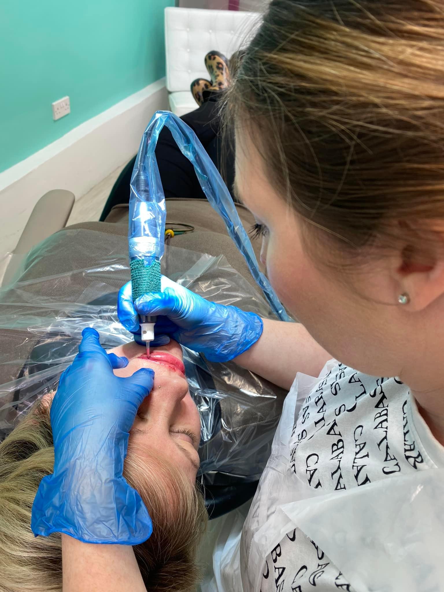 Del tattooing permanent lips on her client