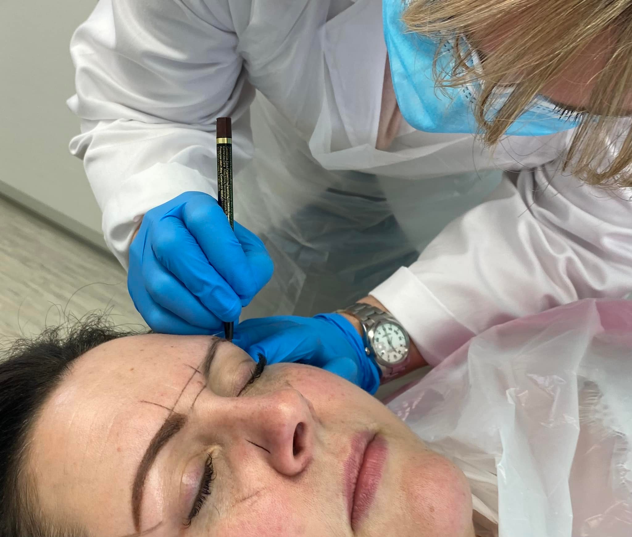 Vikki drawing on brows on her permanent makeup client during training.