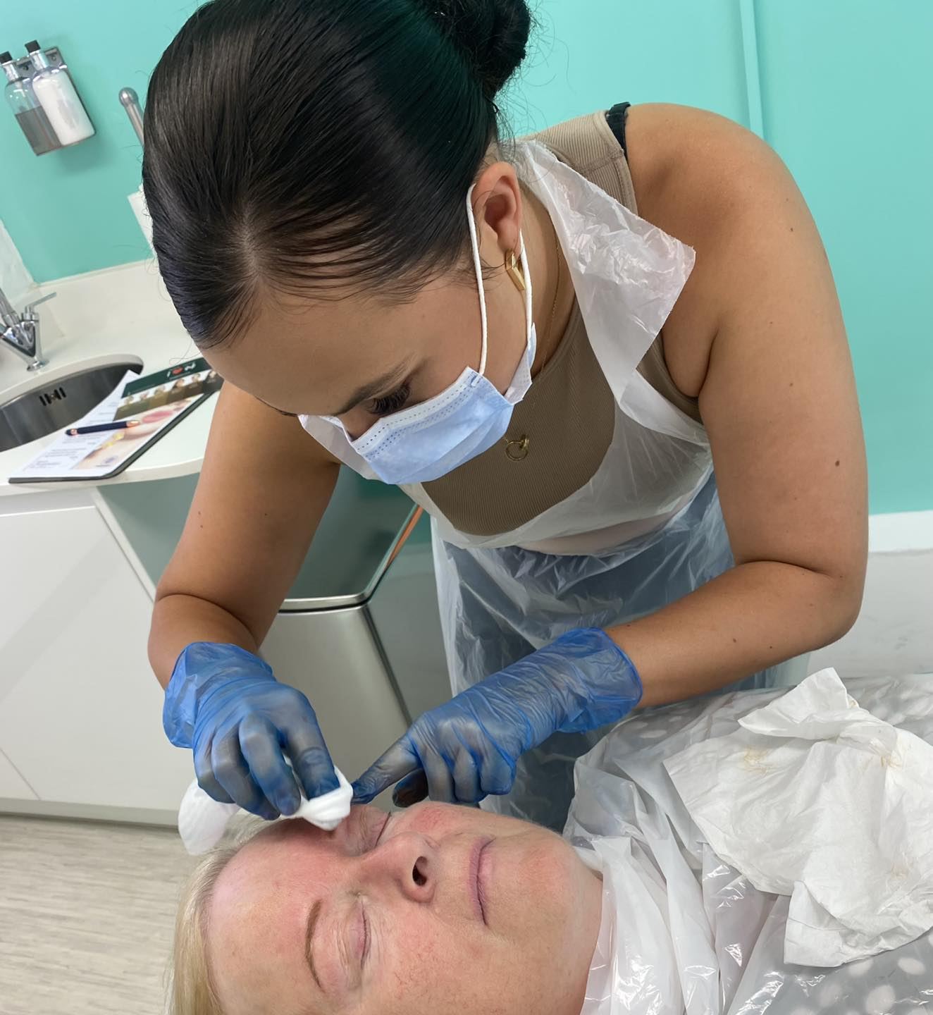 Georgia working on a client performing permanent makeup