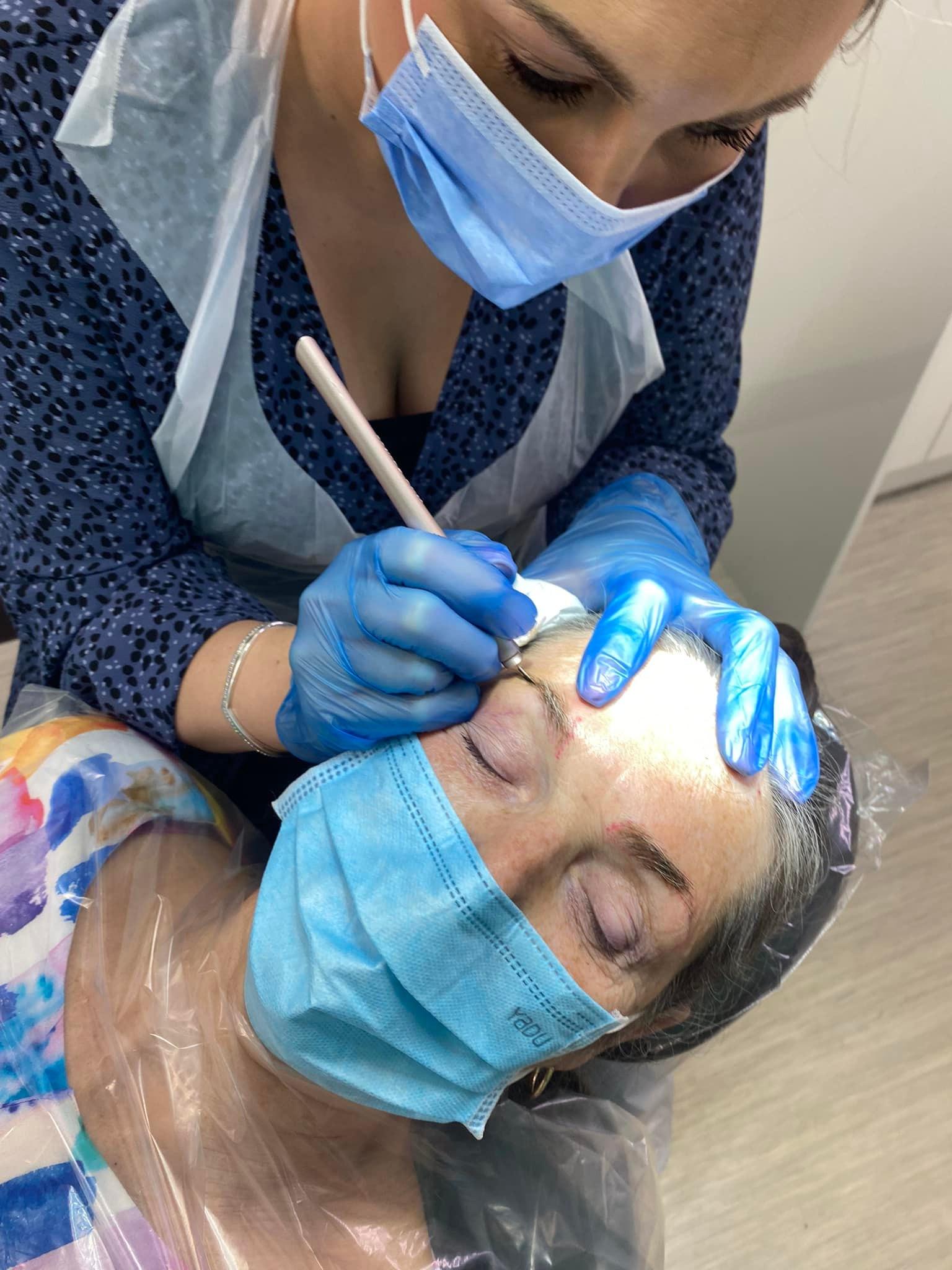 Stacey microblading a client's eyebrow