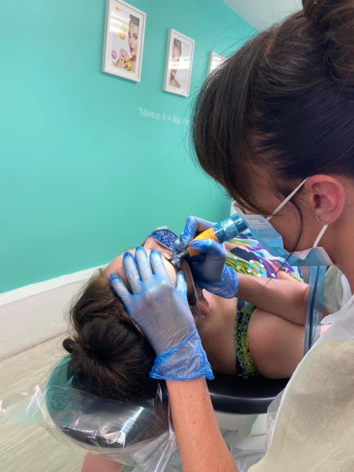 Rachel tattooing a client's brow